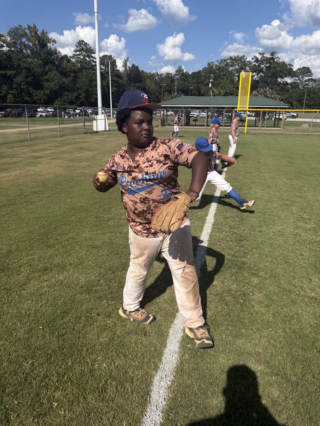 11U National player throwing during pre-game warm-ups
