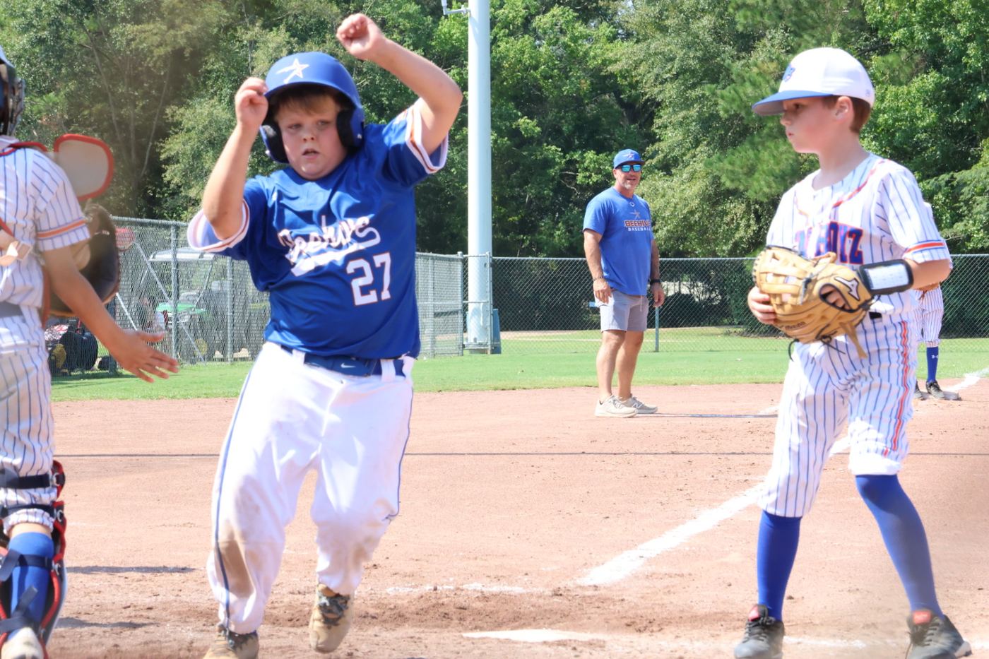 A 9U Beehive Stars runner celebrating as he crosses home plate